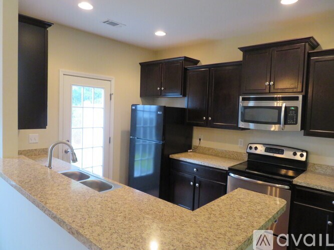 A kitchen with black cabinets and stainless steel appliances.