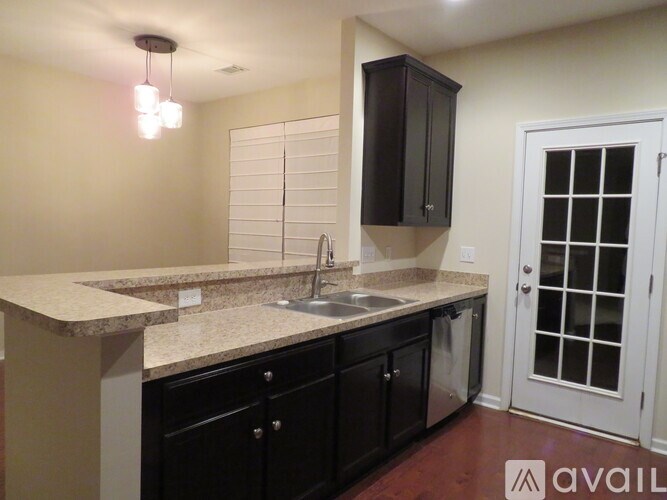 A kitchen with black cabinets and a white sink.