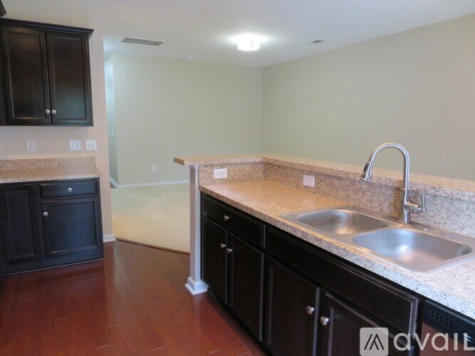 A kitchen with black cabinets and a stainless steel sink.