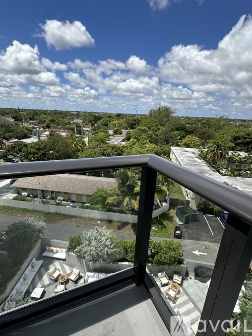 A balcony overlooks a parking lot and a residential area.
