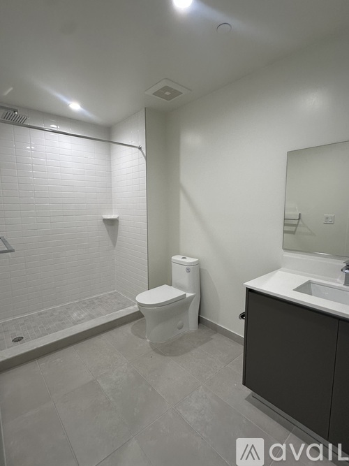 A bathroom with a toilet, sink, and shower.