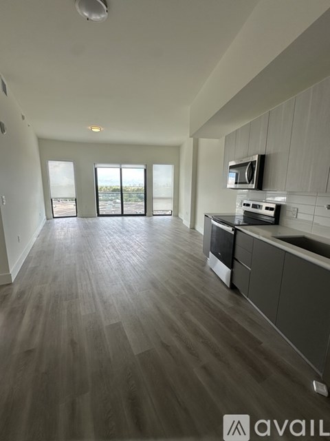 A spacious kitchen with a microwave above the stove and a large window.