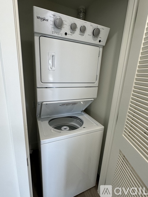 A white Whirlpool dishwasher and washing machine are stacked in a small space.