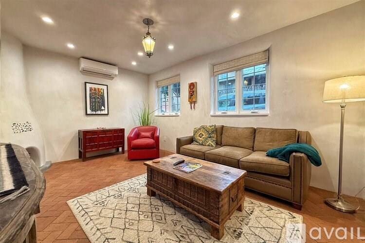 A living room with a brown sofa, a red chair, and a wooden coffee table.