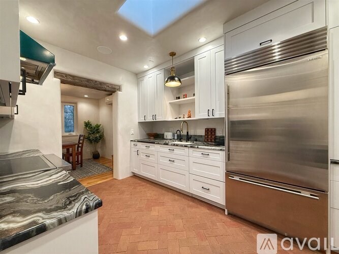A modern kitchen with stainless steel appliances and white cabinets.