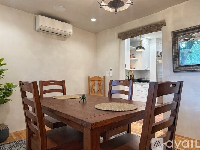 A dining room with a wooden table and chairs.
