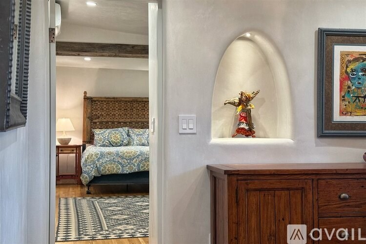 A bedroom with a bed, a nightstand, and a painting on the wall.