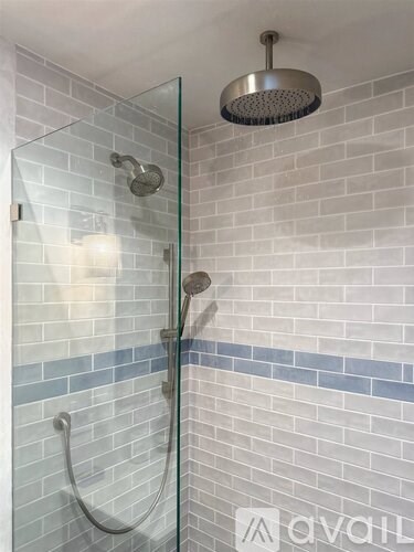 A shower with a glass door and a shower head.