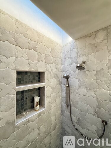 A shower area with a glass block window and a glass block shelf.