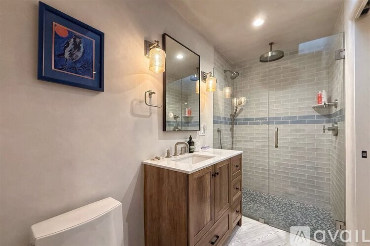 A bathroom with a white sink and a wooden cabinet.