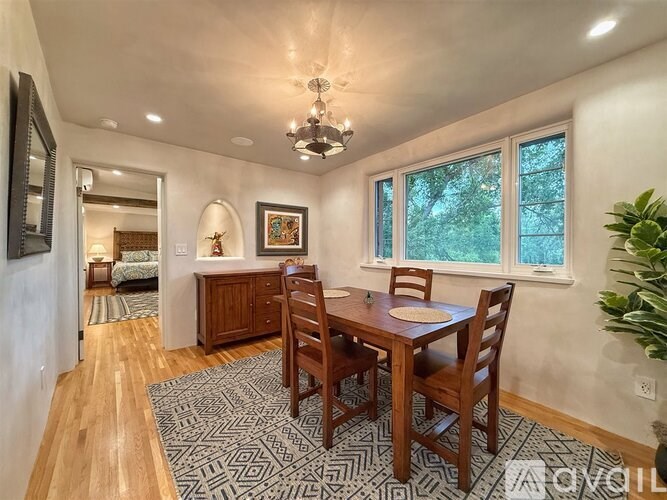 A dining room with a wooden table and chairs.