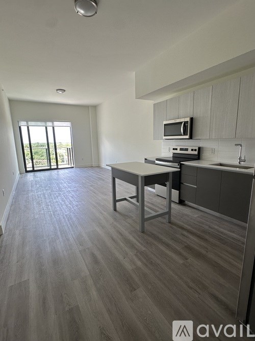 A kitchen with a table and chairs in front of a window.