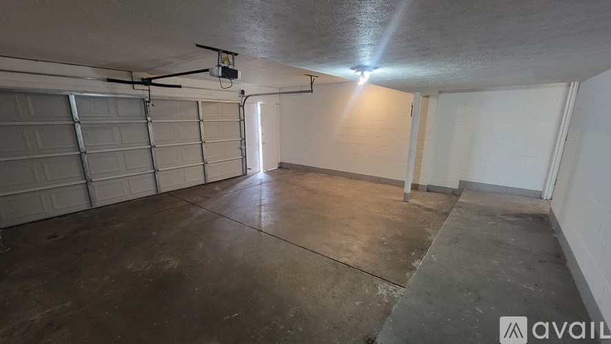 A spacious garage with a concrete floor and a closed white door.