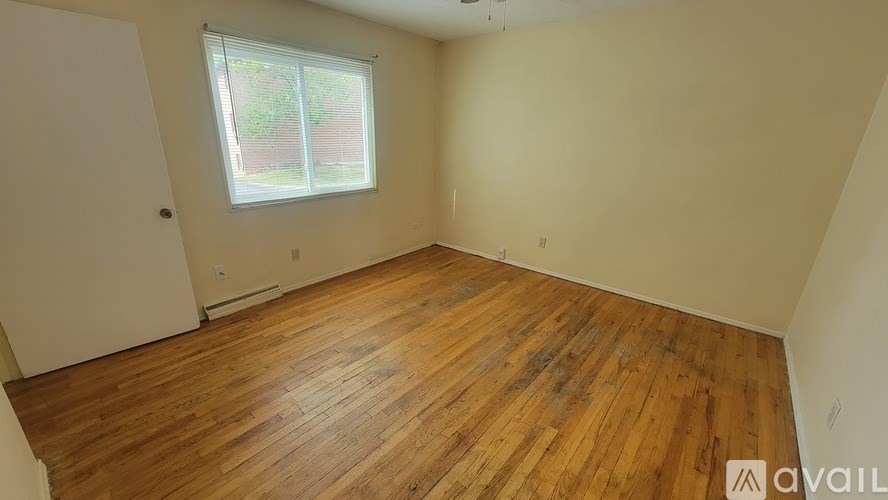 A room with wooden flooring and a window.