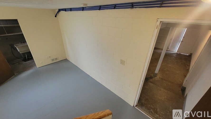 A room with a white wall and a doorway leading to another room.