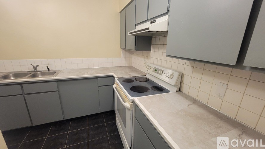 A kitchen with a stove top oven and a double sink.