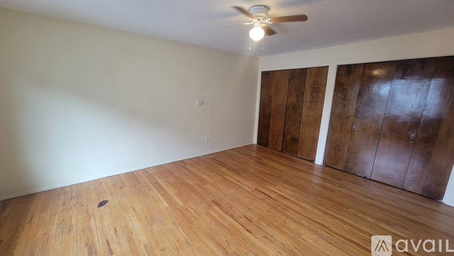 A room with wooden flooring and a ceiling fan.