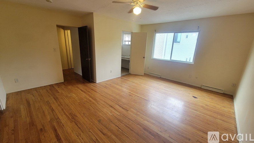 A room with wooden flooring and a ceiling fan.