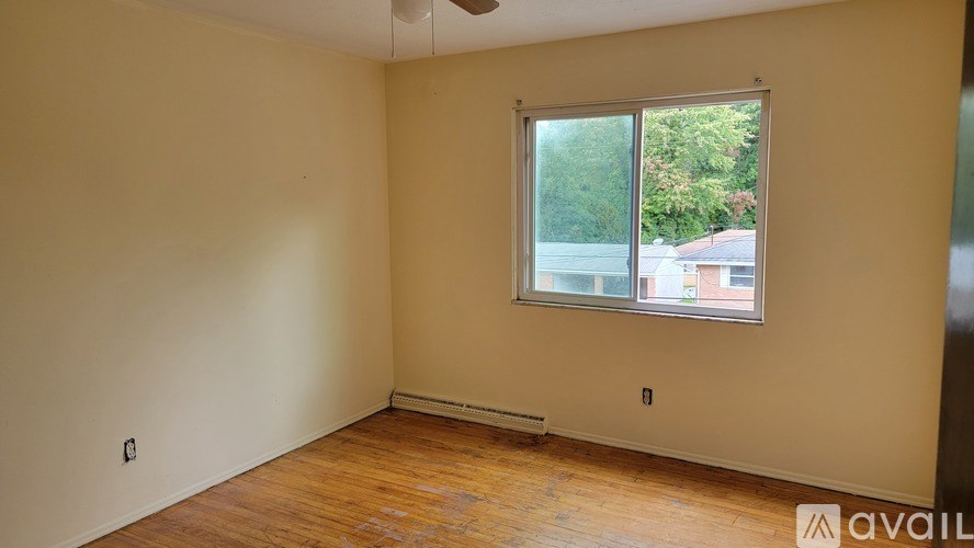 A room with a window and a fan on the ceiling.