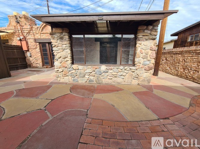 A stone house with a red brick walkway in front.