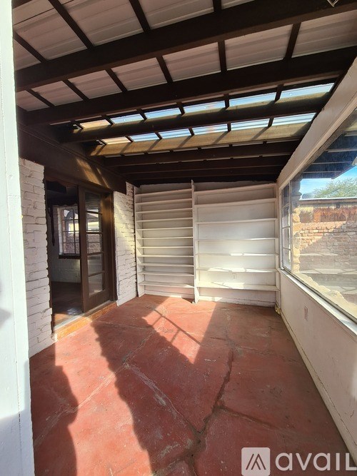 A room with a red floor and a white wall with a window.