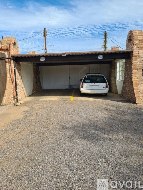 A car is parked in a garage with a brick wall.