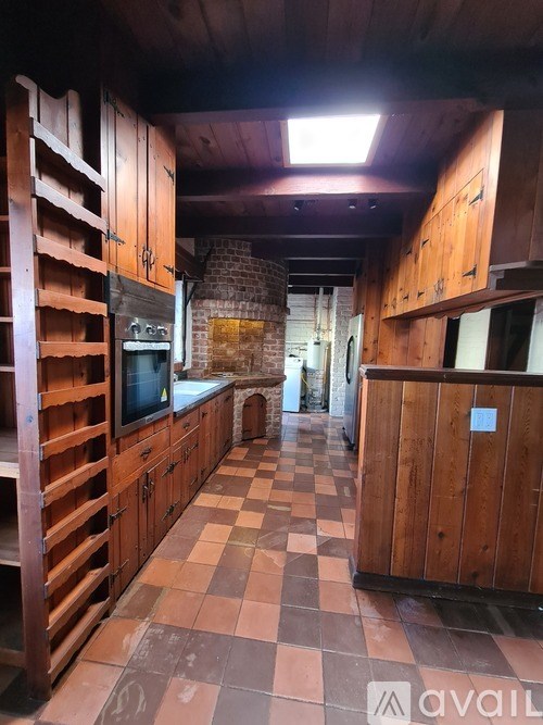 A kitchen with wooden cabinets and a checkered floor.