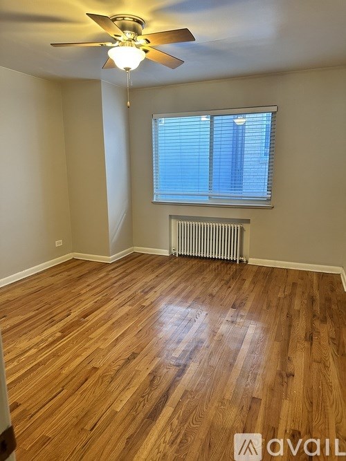 A room with wooden flooring and a ceiling fan.
