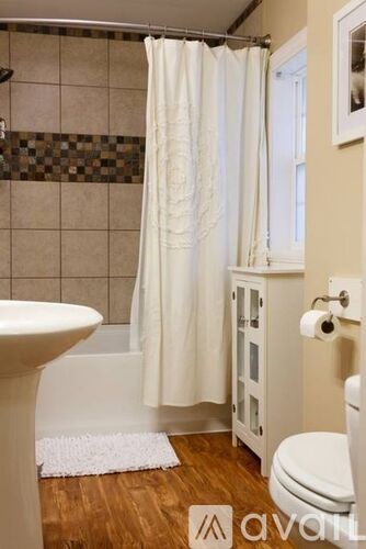 A white toilet sits next to a white sink in a bathroom.