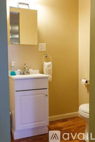 A bathroom with a white sink and a white toilet.