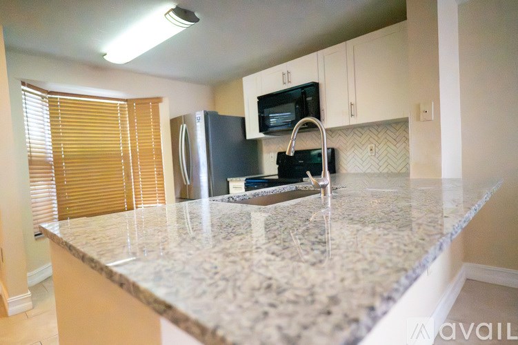 A kitchen with granite countertops and white cabinets.