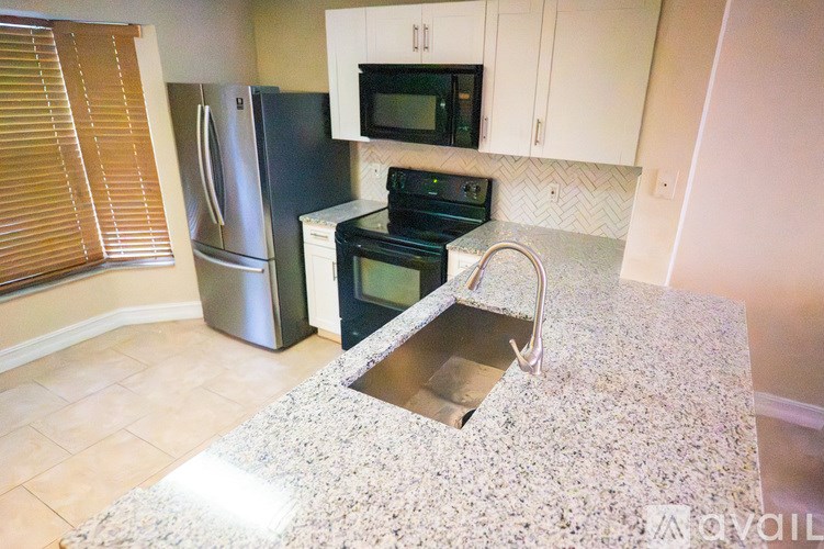 A kitchen with granite countertop and stainless steel appliances.