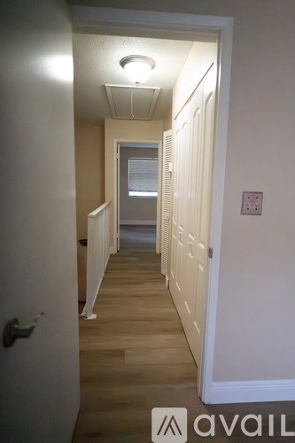 A hallway with a door on the left and a window on the right.