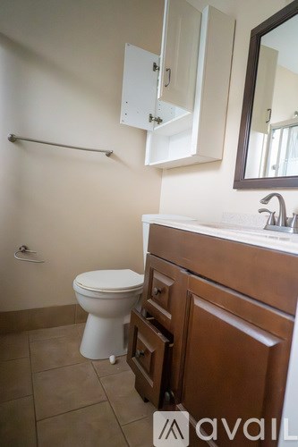 A white toilet sits in a bathroom next to a sink.
