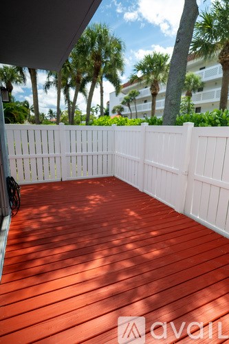 A wooden deck with a white fence and a rope tied to the fence.