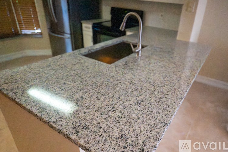 A granite countertop with a sink in the middle.