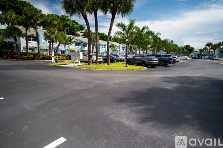 A parking lot with cars and palm trees.