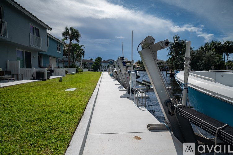 A row of white chairs are lined up on a concrete walkway next to a body of water.