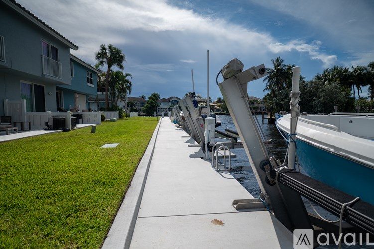 A row of boats are docked at a marina.