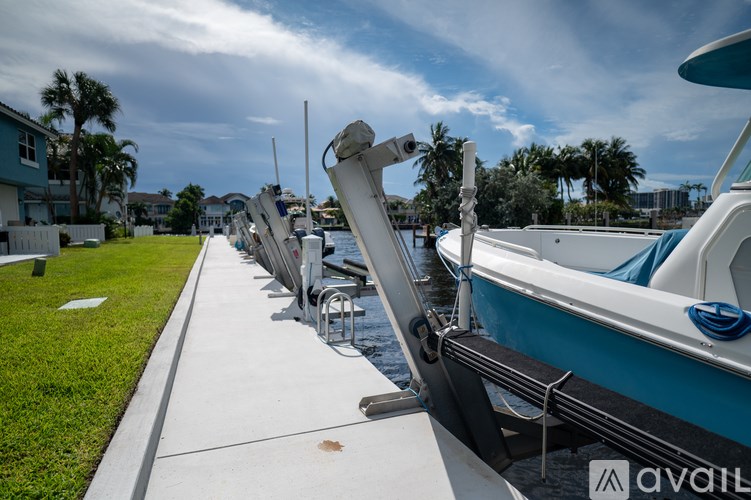 A row of boats are docked at a marina.