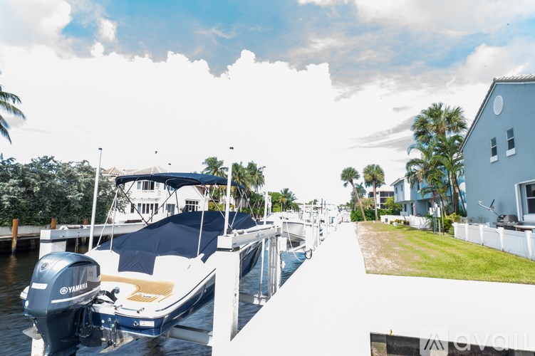 A boat is docked at a marina with a house in the background.