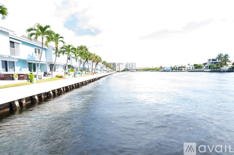 A row of houses with palm trees in front of them.