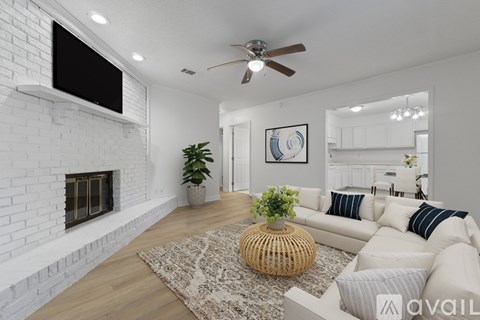 A living room with a white couch and a fireplace.
