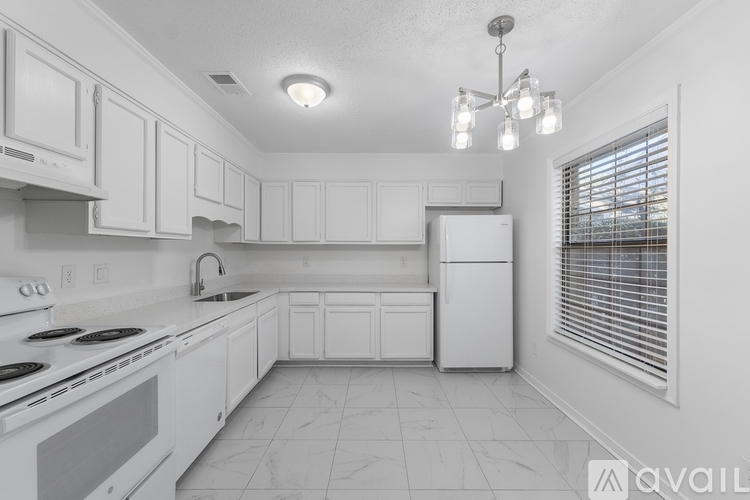 A kitchen with white cabinets and appliances.