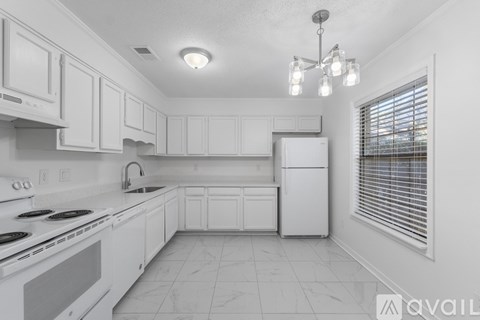 A kitchen with white cabinets and appliances.