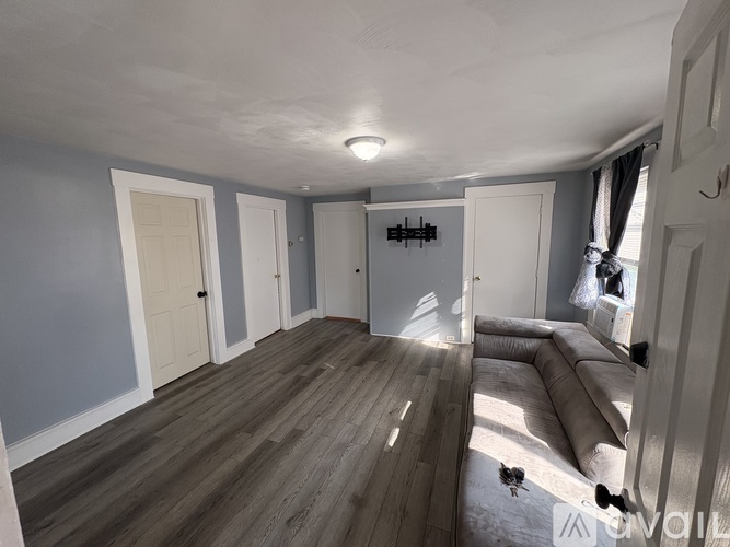A room with wooden flooring and white walls.
