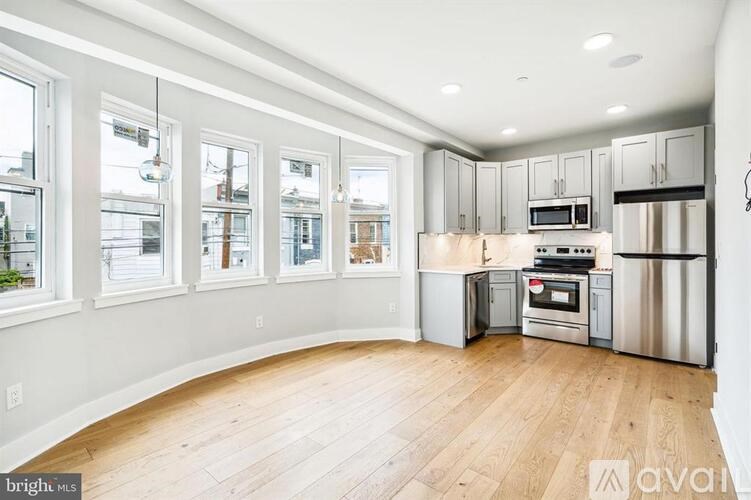 A kitchen with wooden floors and stainless steel appliances.