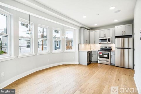 A kitchen with wooden floors and stainless steel appliances.