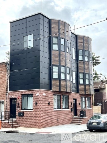 A modern black and brown building with a brick base.