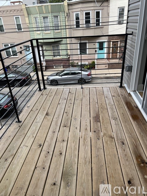 A wooden deck with a railing and a car parked on it.